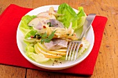 Marinated herring with apple and lettuce on plate with fork