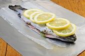 Raw trout fish with herb filling and lemon on foil, step 2