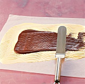 Schokolade, weiße Kuvertüre wird m. dunkler Kuvertüre bestrichen