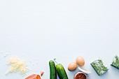 Cheese, cucumber, eggs and spinach on white background