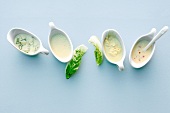 Four different salad dressings in sauceboats, overhead view