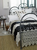 Black and white plaid bed sheet with crochet on iron bed