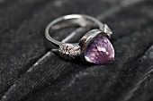 Close-up of syllable ring with shell ornament and amethyst stone