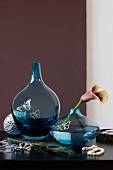 Blue flower vase and various homemade accessories on wooden surface
