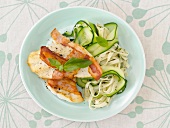 Fish with bacon, vegetables and noodles on plate