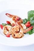 Close-up of shrimp with peppers and arugula on dish