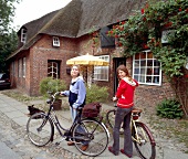 Two woman standing with bicycle in Westerland, Sylt, Germany