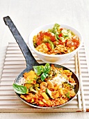 Bowl of shanghai noodles and bulgur and vegetable stir fry in pan