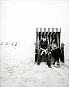 Two woman sitting in beach chair on West beach in Sylt, Germany, black and white