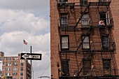 Woman sitting on fire escape staircase in building