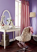 Dressing table with chair and mirror against purple wall