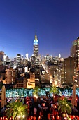View of cityscape overlooking people sitting on rooftop bar at New York, USA