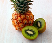 Close-up of pineapple and halved kiwi on white background