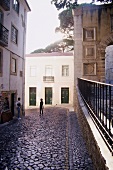 People on cobbled street of Castle of Sao Jorge in Portugal