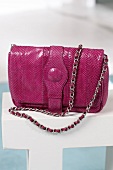 Close-up of pink python leather bag with chain strap