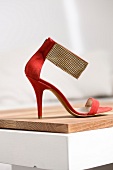 Close-up of red high heel sandal with golden metallic belt