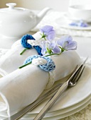 Close-up of white napkin wrapped in knitted napkin rings