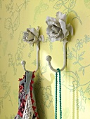 Rose shaped clothes hooks of metal on wall
