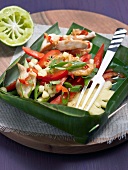 Chicken salad with pineapple and fork in leaf bowl