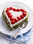 Heart shaped cake with strawberries and nuts on plate