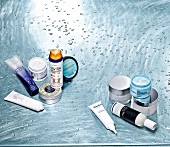 Various hair products with water droplets on blue background