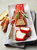 Pepper and goat cheese terrine with baguette on long tray, France