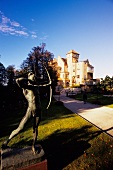 Statue holding bow and arrow near stone castle, Salzburg, Austria