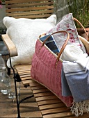 Bag with blanket and pillows on wooden bench