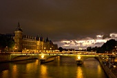 Illuminated Pont au Change bridge at evening in Paris, France