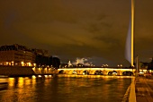 Illuminated Pont au Change bridge at evening in Paris, France