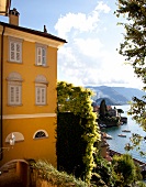 Yellow painted house in front of Lake Como, Varenne, Lombardy, Italy