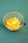 Apple and orange compote in glass bowl with spoon