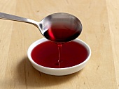 Raspberry juice being poured in white bowl