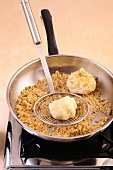 Roasting nougat dumplings in apricots in frying pan, step 3