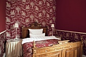 Bedroom with bed, side table, side lamps and pink coloured walls