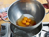 Egg yolks with sugar in pan over boiling water for preparation of zabaglione, step 2