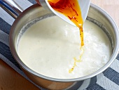 Adding saffron water in milk for colour for preparation of sauce