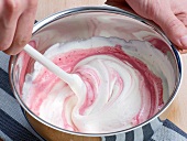 Adding beetroot sauce in cream for colour while preparing sauce