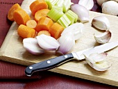 Various chopped vegetables on wooden board for preparation of veal jus, step 2