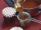 Filling veal jus in glass jars with ladle, step 10