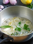 Various vegetables and herbs being cooked in pan while preparing sauce, step 1