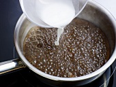 Close-up of corn flour-water mixture being added in pan