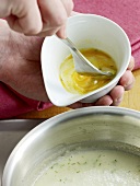 Close-up of egg yolk being mixed with fork for binding, step 1