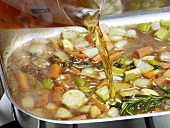Close-up of liquid being poured in mixture for preparation of bratenjus, step 4