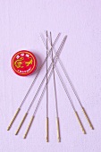 Close-up of acupuncture needles and balm on purple background