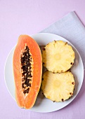 Pineapple slices and papaya on plate for Enzyme therapy