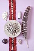 Stones, feather and other alternative medicine on purple background, overhead view
