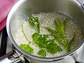 Herbs being cooked in saucepan for preparation of hollandaise sauce, step 1