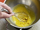 Close-up of mayonnaise and egg yolks being mixed with whisk, step 2