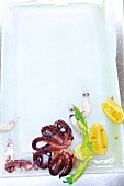 Pulpo, celery and lemon on chopping plate